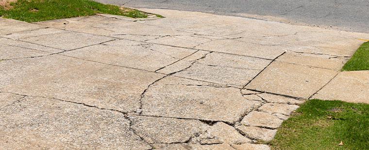 Cracked driveway that needs to be repaired.