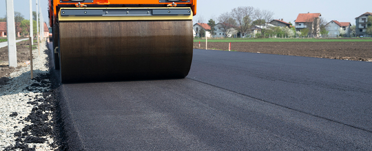 Steam Roller laying a paved road flat.
